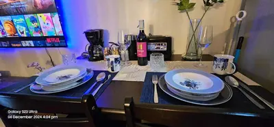 a table with plates and glasses and a bottle of wine at Relaxing Chic Hotel Like with Manila Bay view in Manila