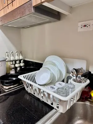 a dish rack with plates and other dishes in a kitchen at Hearth of Ember at Shore 3 in Manila