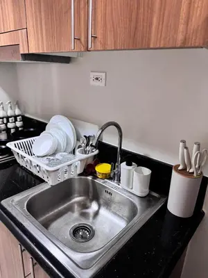 a kitchen sink with plates and dishes in a kitchen at Hearth of Ember at Shore 3 in Manila