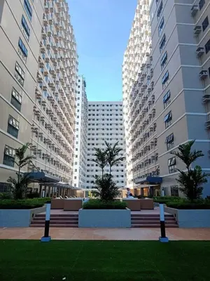 two tall buildings with palm trees in a park at Green 2 - Gems Suite in Dasmariñas