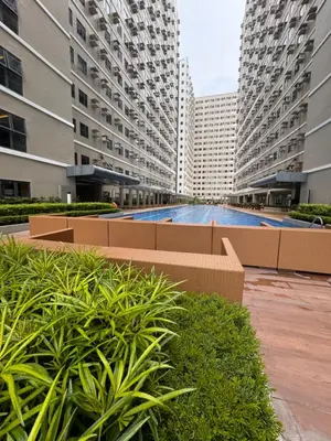 a pool in the middle of two tall buildings at Green 2 SMDC - STUDIO TYPE Condo - Gems Suite Staycation in Dasmariñas