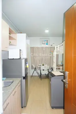 a kitchen with a refrigerator and a table at Studio City Alabang Pool Access Free for 2 Wifi & Netflix SC1 in Manila