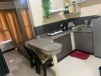 a small kitchen with a counter and a table at Birch Tower Malate Accommodation by T&T in Manila