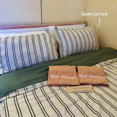 a bed with two towels on top of it at Cozy Stay Near BGC & Airport in Manila
