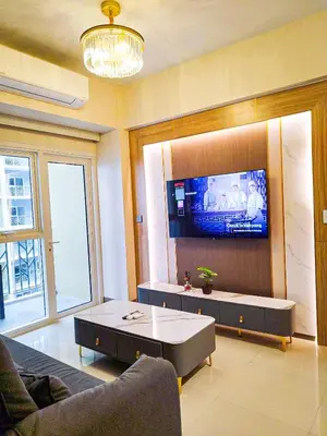 a living room with a couch and a tv on the wall at Cozy 3BR near Airport and Okada in Manila