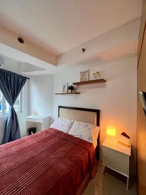 a bedroom with a bed with a red bedspread at Relax and Unwind A Homey Escape Near MOA and NAIA in Manila