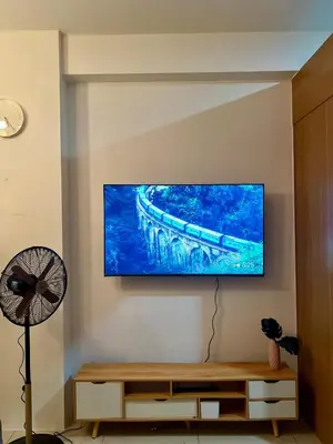 a living room with a flat screen tv on the wall at Relax and Unwind A Homey Escape Near MOA and NAIA in Manila