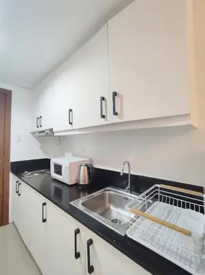 a kitchen with a sink and a microwave at Relax and Unwind A Homey Escape Near MOA and NAIA in Manila
