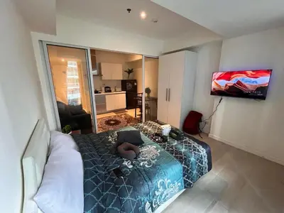 a room with a bed and a television in it at Staycation In Azure Parañaque in Manila