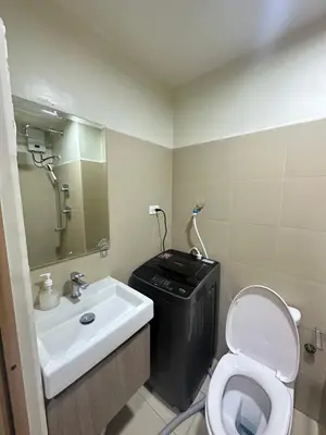 a bathroom with a white toilet and a sink at Shore 3 staycation in Manila