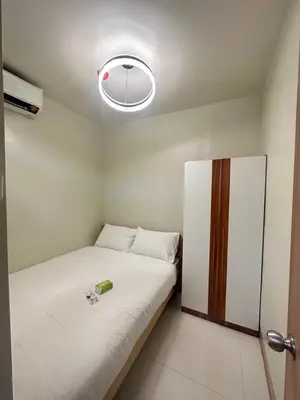 a small bedroom with a bed and a light at Shore 3 staycation in Manila