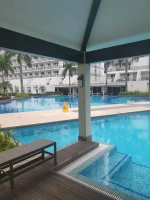 a swimming pool with a bench next to a building at Macc staycation in Manila