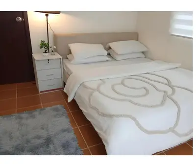 a bed with white sheets and a white night stand at 2BR Pioneer Woodland connected to Metro Rail Station SM Light,BONI Mandaluyong, Metro Manila,Philippines in Manila