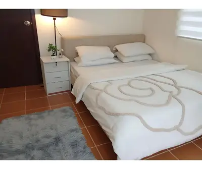 a bedroom with two beds and a nightstand with a bedskirts at 2BR Pioneer Woodland connected to Metro Rail Station SM Light,BONI Mandaluyong, Metro Manila,Philippines in Manila