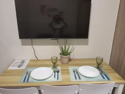 a table with two plates and a tv on a wall at Reden Staycation in Manila