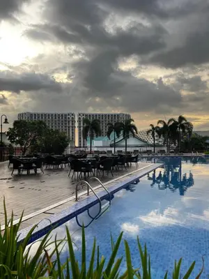 a swimming pool with tables and chairs and a building at Faerydae Suites - Free Pool Access in Manila