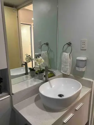 a bathroom with a sink and a large mirror at Away from but close like family room in Manila