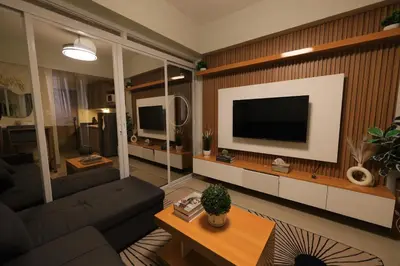 a living room with a couch and a television on a wall at GM Suite near SM MOA, Pasay I 2 Beds I City & Bay View in Manila