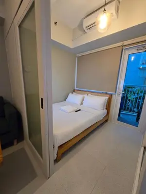 a small bedroom with a bed and a window at Jazz Residence- Makati in Manila
