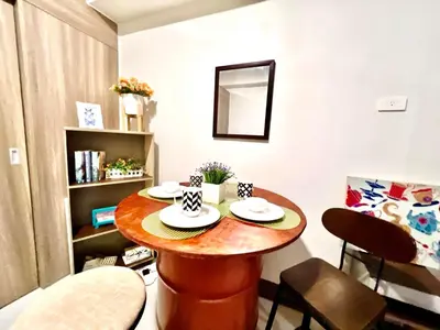 a small room with a table and chairs in it at Central Ortigas Center Condo in Manila