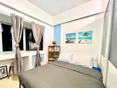 a bedroom with a bed and two windows at Perfect Location BGC - Mckinley in Manila