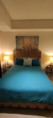 a bedroom with a blue bed with two lamps at Azure Cozy Vibe Condo Unit in Manila