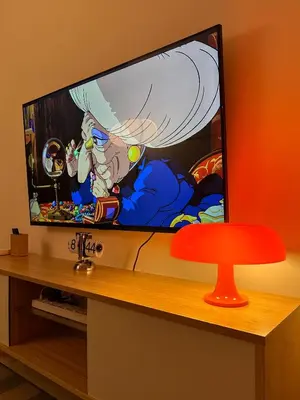 a flat screen tv sitting on top of a table at Cozy Mid-Century Condo with a Skyline View in Manila