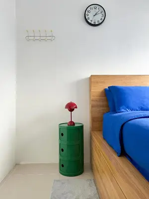 a bedroom with a bed and a clock on the wall at Cozy Mid-Century Condo with a Skyline View in Manila
