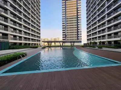 a swimming pool in the middle of two tall buildings at Luxe 1BR with WiFi, Karaoke and Balcony Near SM Megamall in Manila