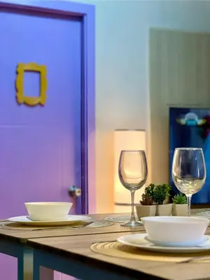 a table with two plates and wine glasses on it at FRIENDS TV Staycation in Manila
