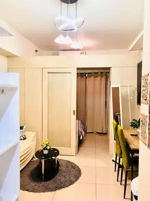 a living room with a table and a dining room at JAZZ RESIDENCES- Amaya Stays in Manila