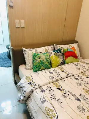 a bed with pillows on it in a room at JAZZ RESIDENCES- Amaya Stays in Manila