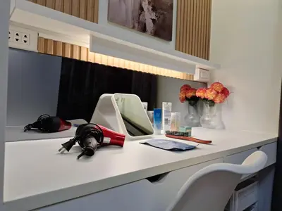 a bathroom counter with a mirror and flowers on it at Velvet Room near MOA with a Cozy, Comfy Bed in Manila