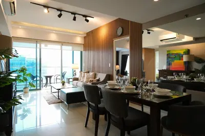 a dining room and living room with a table and chairs at One Uptown Premium 2BR Suite in Manila