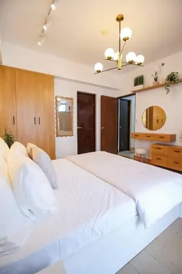 a large bedroom with a large white bed with white pillows at Cylo's Place Manhattan in Manila