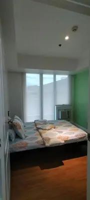 a bedroom with a large bed in front of a window at Azure Family Room Condo Unit in Manila