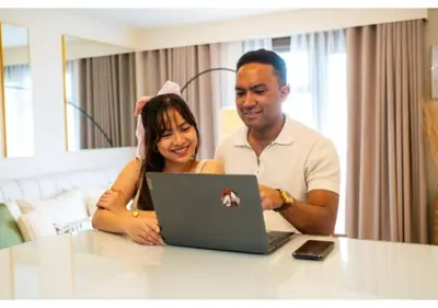 a man and a woman looking at a laptop at The Bay Nest in Manila