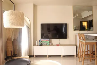 a living room with a white cabinet and a tv at The Bay Nest in Manila