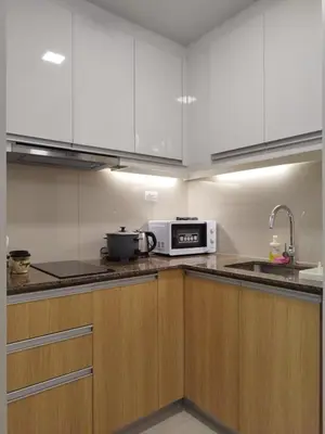 a kitchen with white cabinets and a microwave at Savvy Suite 1BR near Okada in Manila