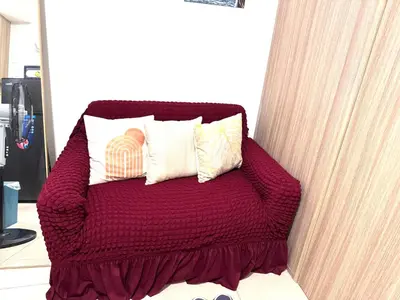 a red bed with three pillows on top of it at La Chicka staycation in Manila
