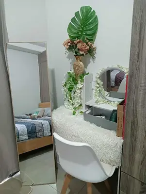 a mirror and a white chair in a bedroom at La Chicka staycation in Manila