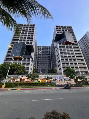two tall buildings with a sign in front of a street at La Chicka staycation in Manila