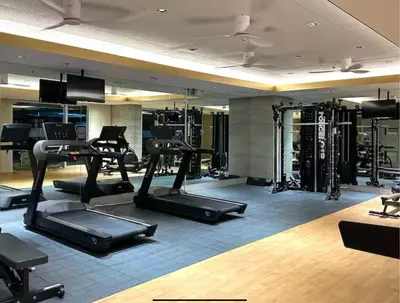 a gym with several treadmills and exercise machines at Cozy Mid-Century Condo with a Skyline View in Manila