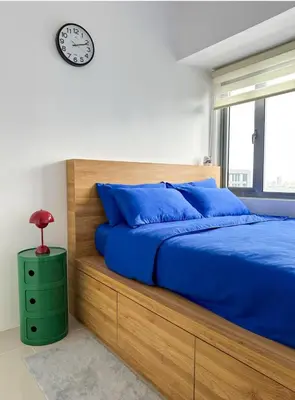 a bedroom with a bed and a clock on the wall at Cozy Mid-Century Condo with a Skyline View in Manila
