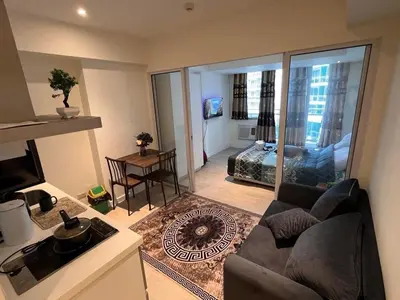 a living room with a couch and a view of a bedroom at Staycation in Azure Paranaque in Manila