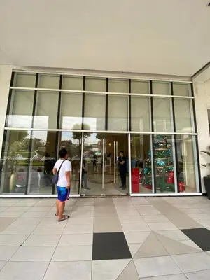 a person standing in front of a glass building at JNL Condotel in Manila
