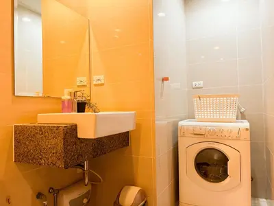 a bathroom with a washing machine and a sink at Prime 1br Condo Infront Grand Hyatt BGC #oursw20d1 in Manila