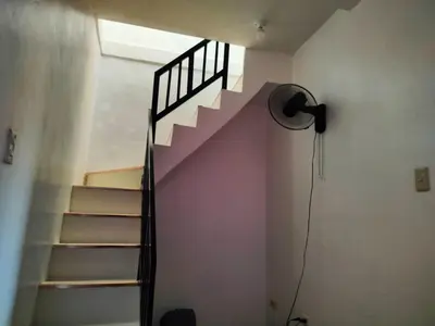 a room with a spiral staircase with a fan at Simple, Spacious Home To Stay, 2Bedrooms 2 Toilet & Bath 1 car garage in Uldugan