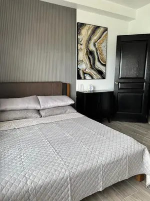a bedroom with a bed and a painting on the wall at Condo in Malate in Manila