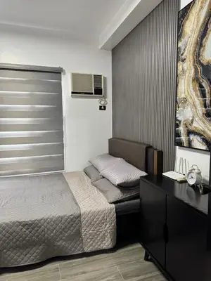 a bedroom with a bed and a desk and a window at Condo in Malate in Manila